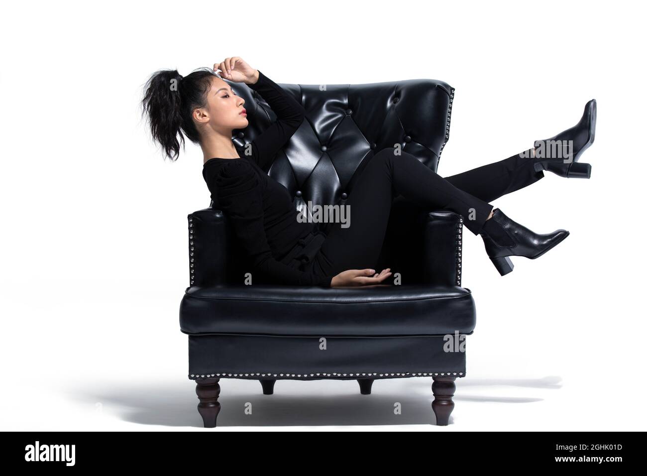 Beautiful young woman sitting on a luxury sofa Stock Photo - Alamy