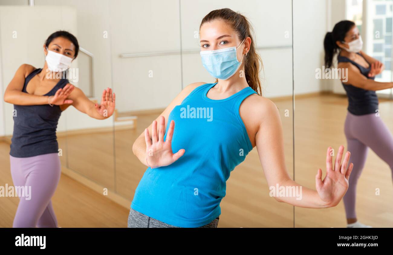 Girl in protective mask enjoying active dancing in dance studio Stock Photo