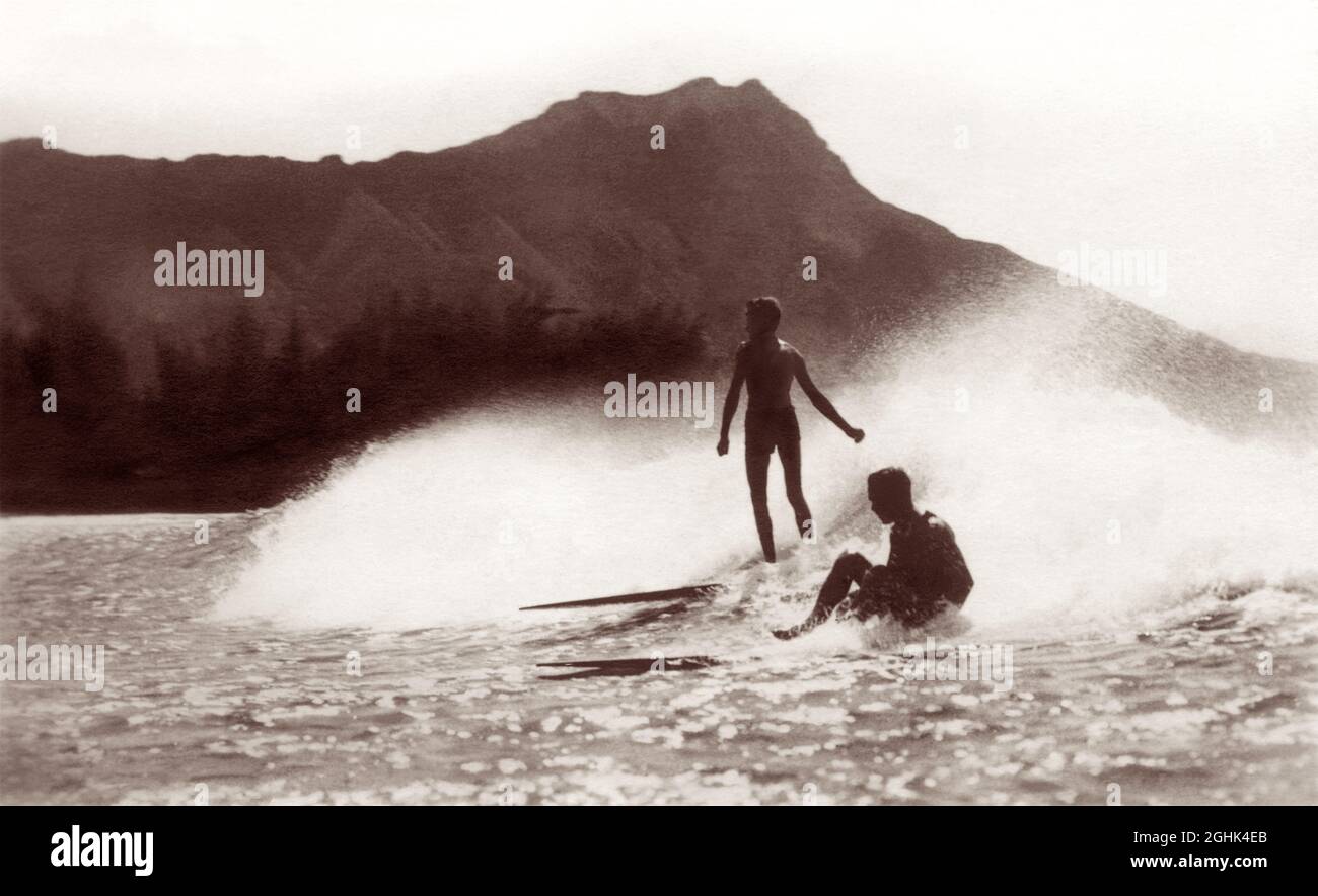 Early 20th century vintage surfing photo of surfers riding a wave on