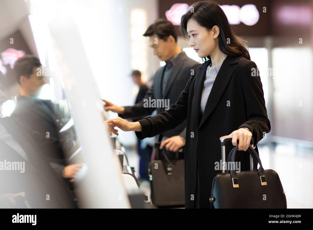 In Person Check In Business people doing self check-in at airport Stock Photo - Alamy