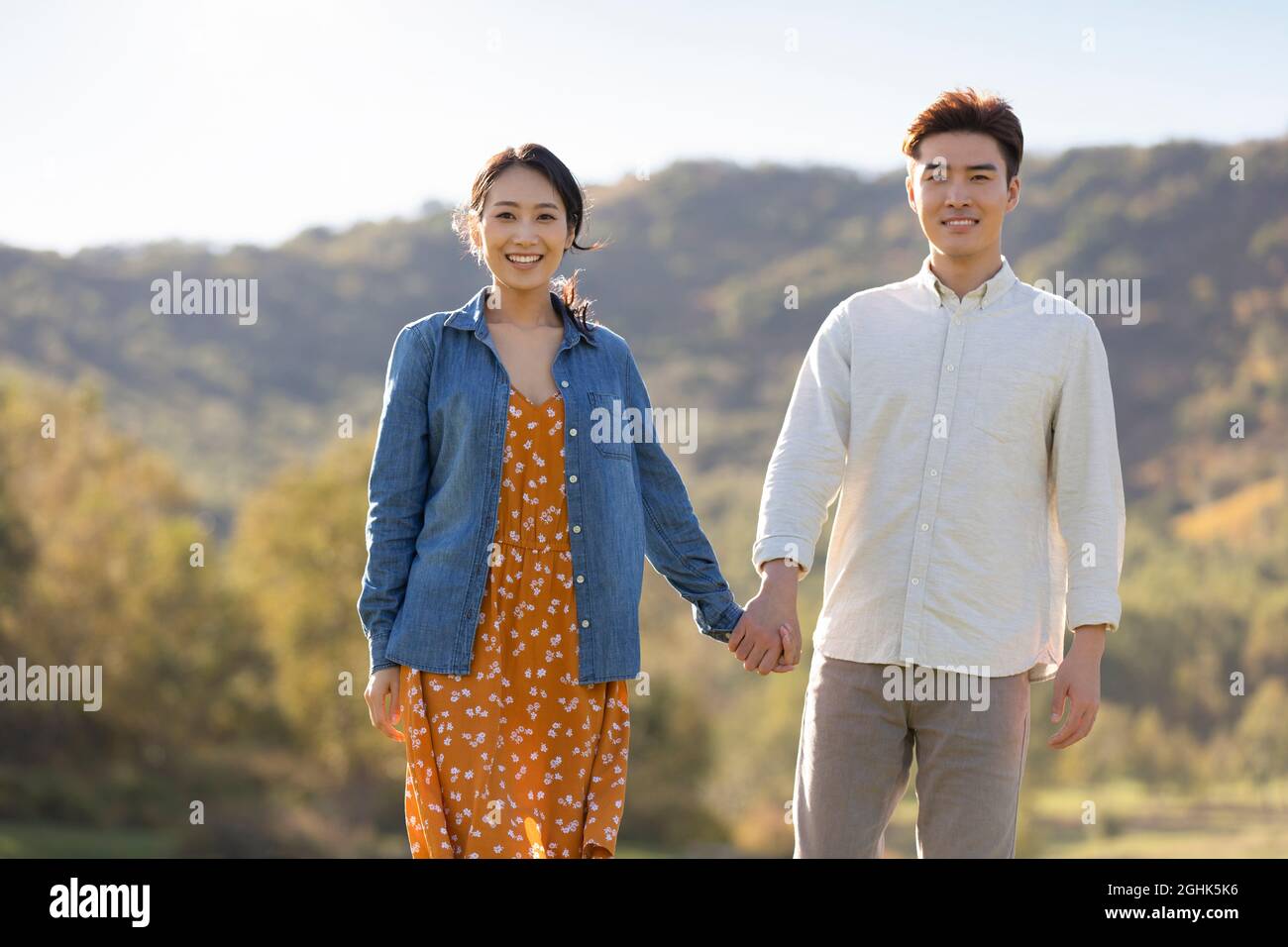 Happy young couple holding hands Stock Photo - Alamy