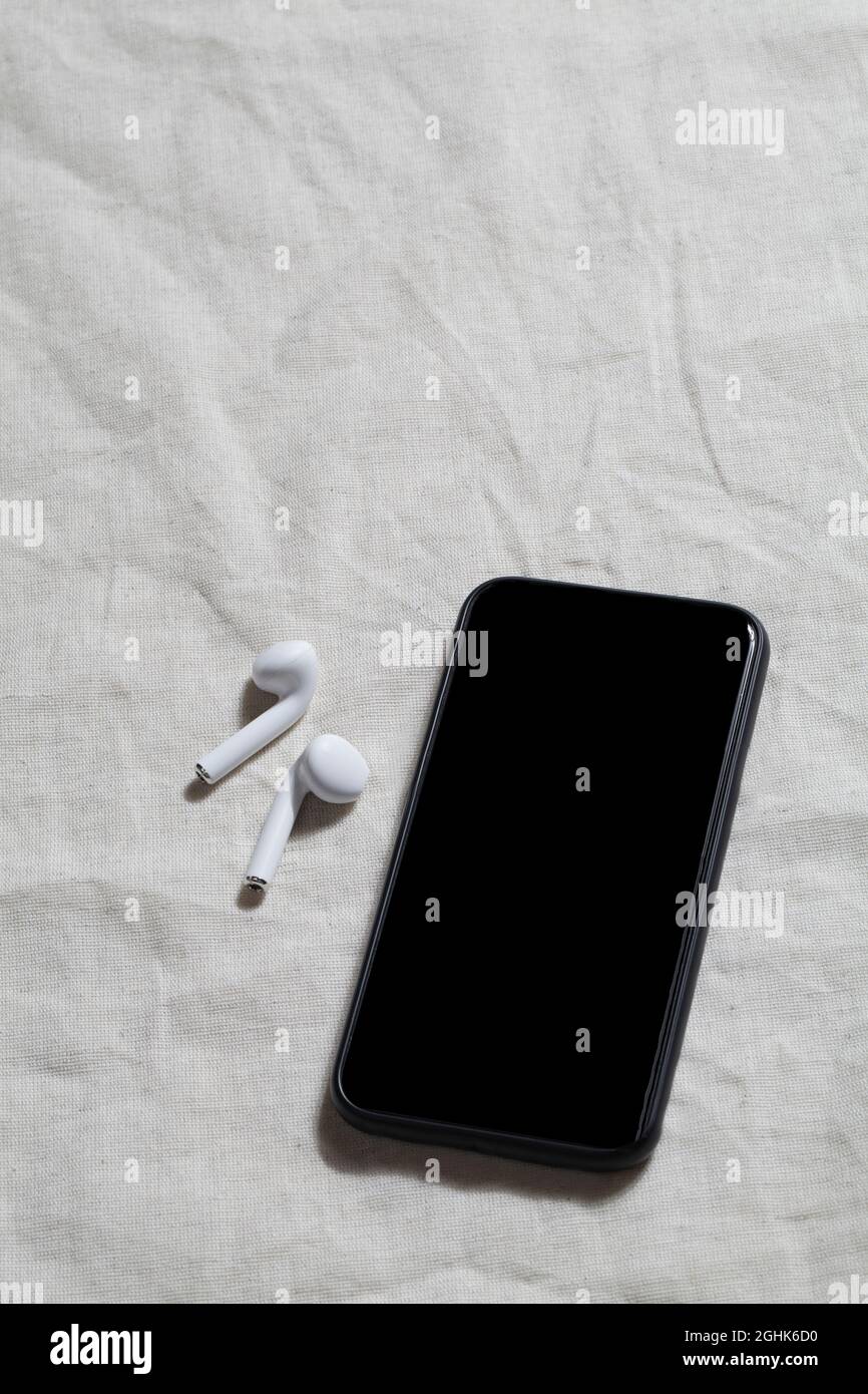 workplace with phone and headphones on linen textile. Kinfolk designed. minimal, stylish concept. working table. Stock Photo