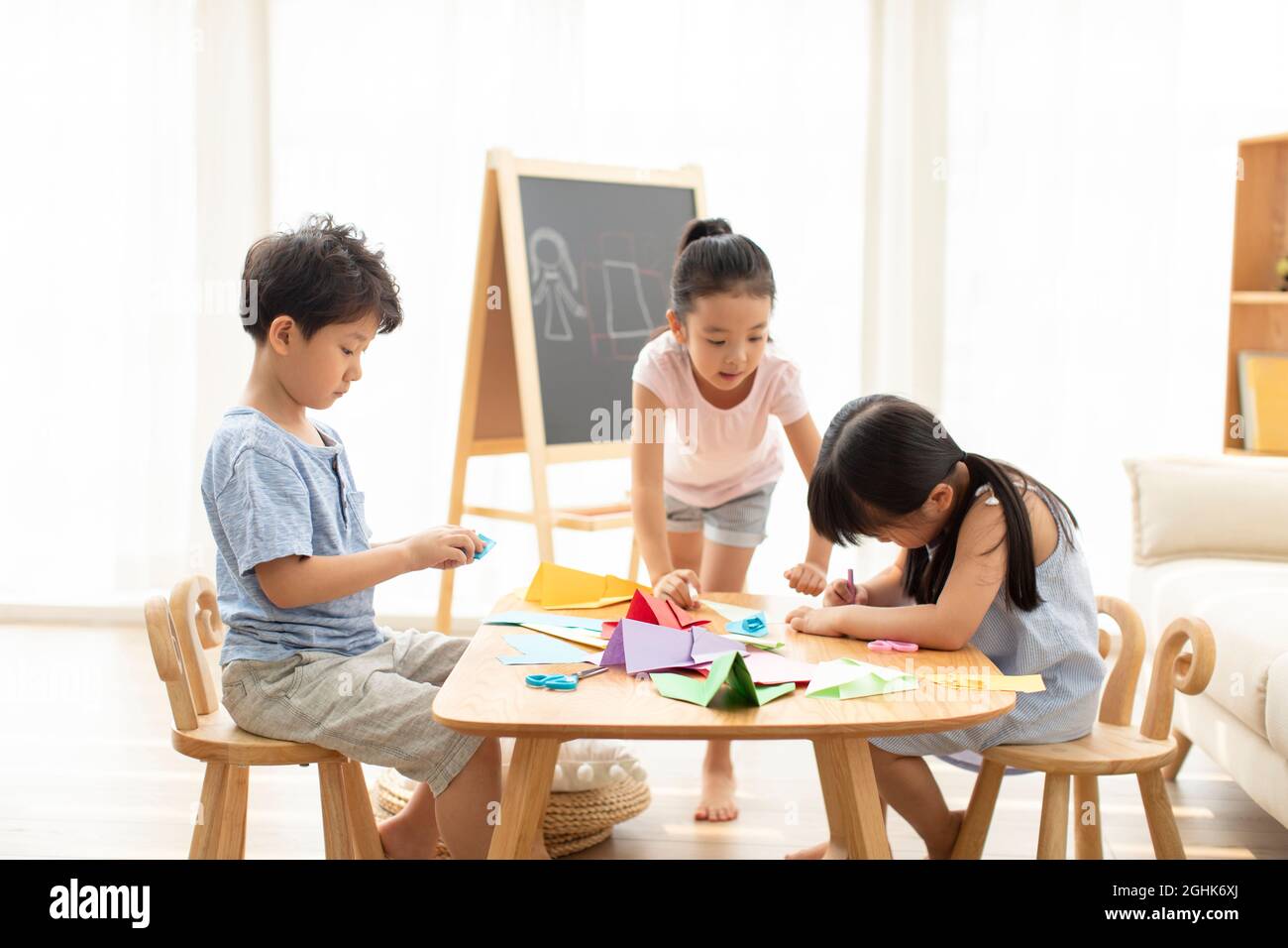 Cute children doing paper craft in living room Stock Photo - Alamy