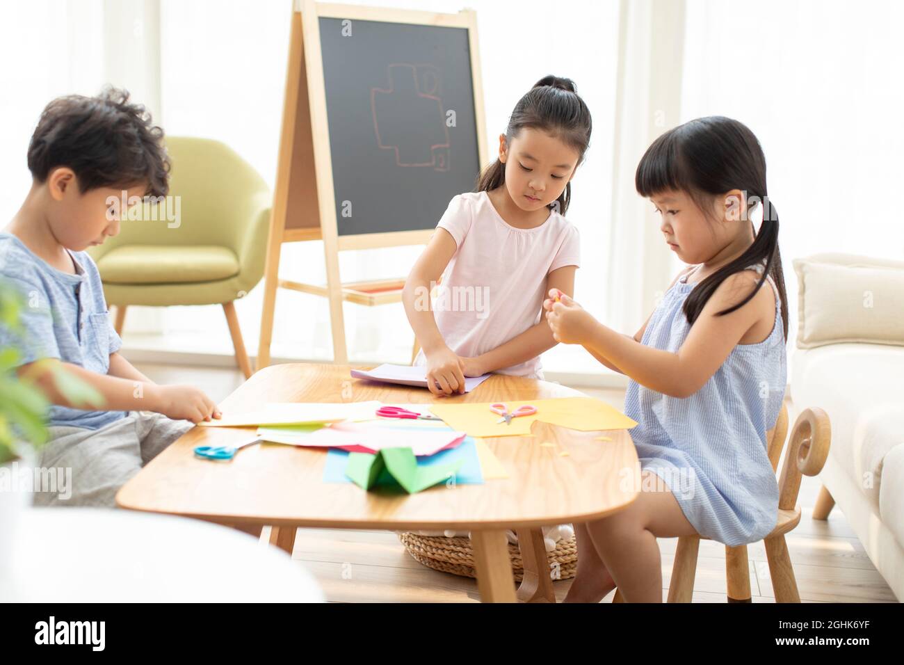 Cute children doing paper craft in living room Stock Photo - Alamy