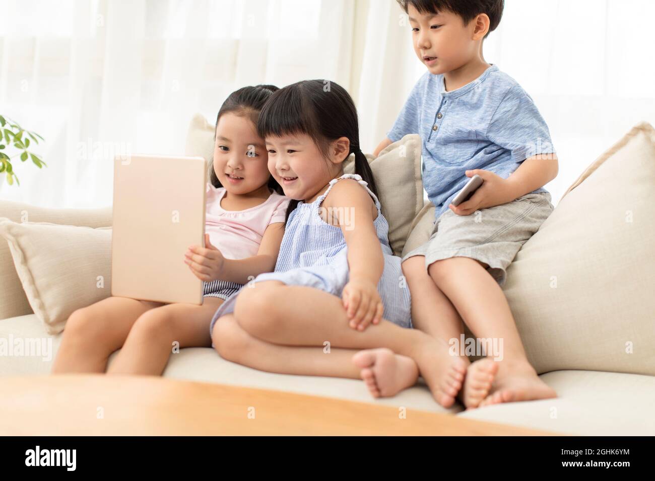 Cute children using digital tablet on sofa Stock Photo