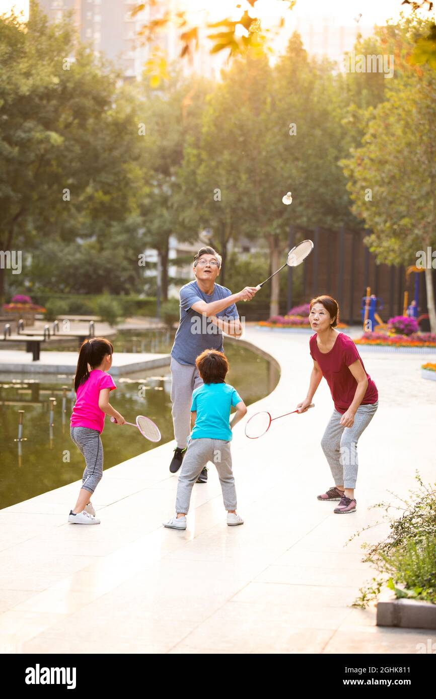 Happy family playing badminton in park Stock Photo Alamy