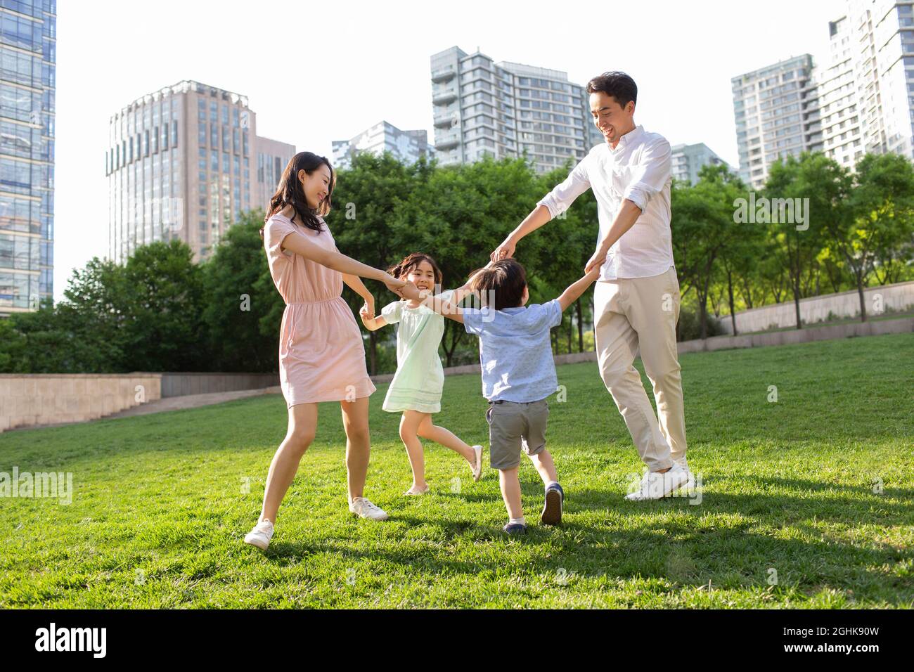 Happy young family playing in park Stock Photo - Alamy