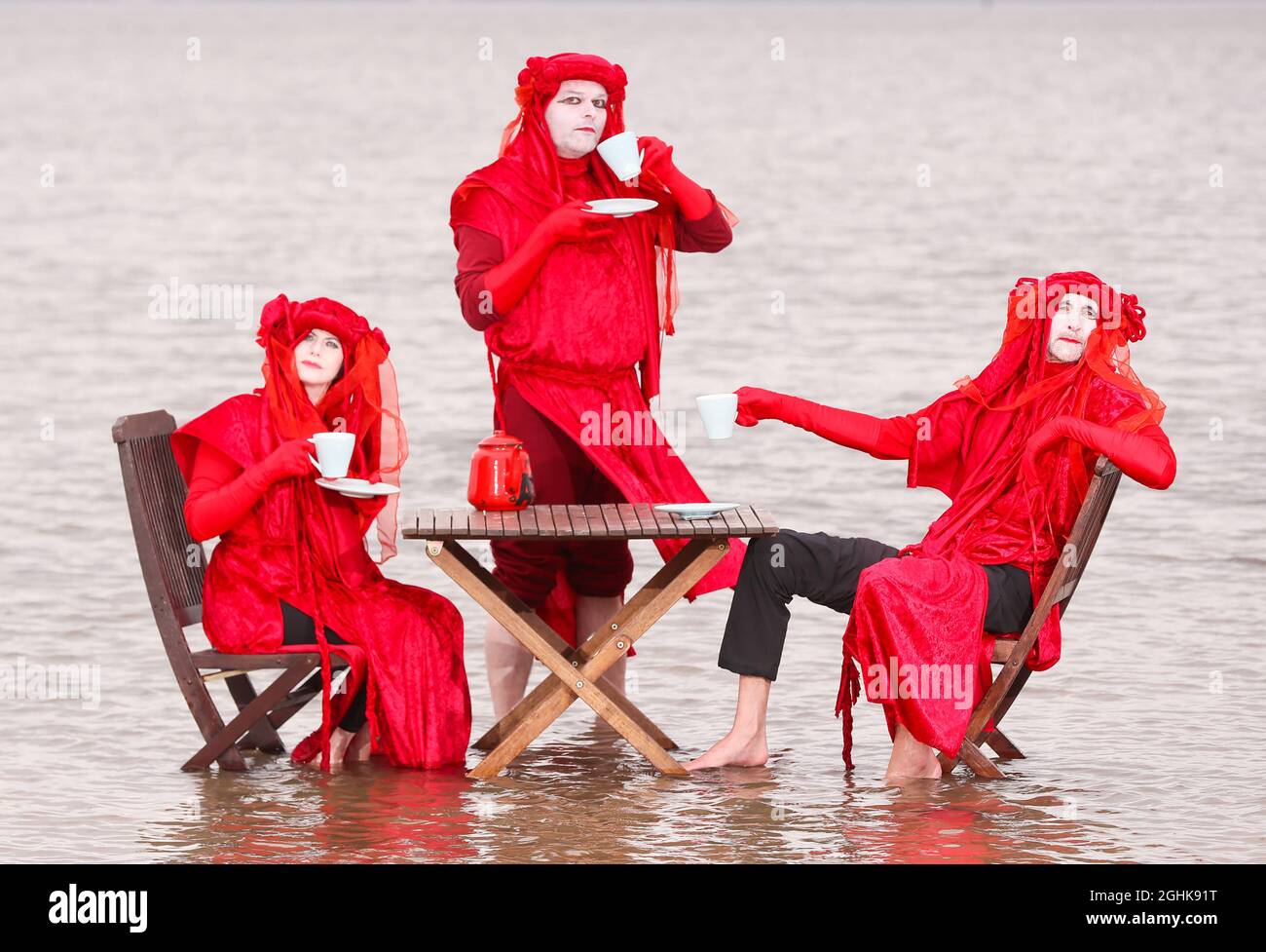 Extinction Rebellion’s Red Rebels hold a Tea in the Sea protest in Belfast Lough at Seapark, Co. Down, in Northern Ireland. Stock Photo
