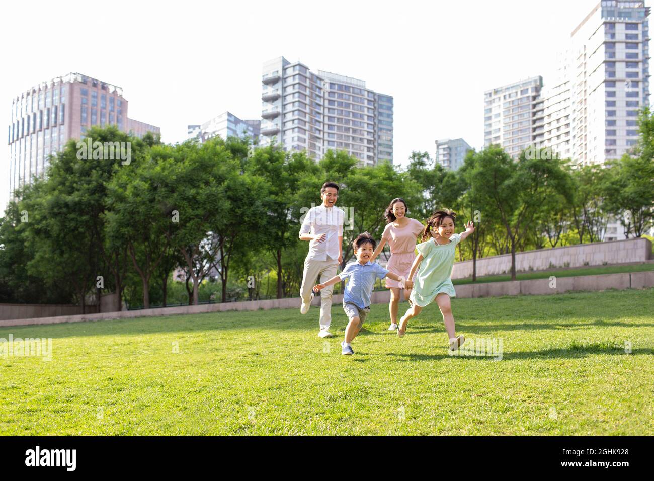 Happy young family playing in park Stock Photo - Alamy