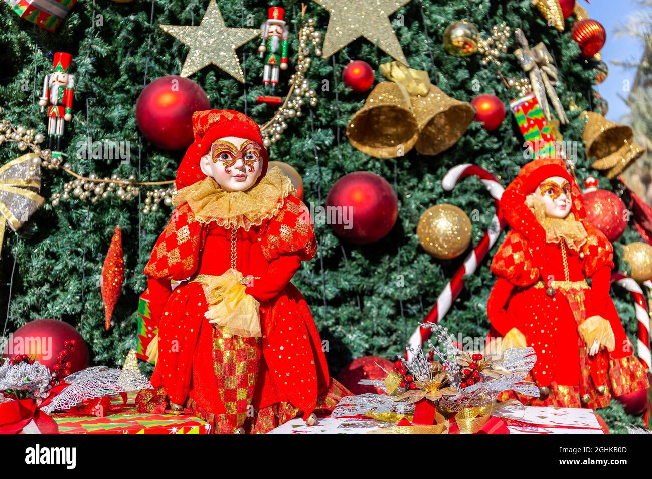 Two christmas elfs dressed in red, with christmas tree decorations in the background, Town Square, Dubai, United Arab Emirates. Stock Photo