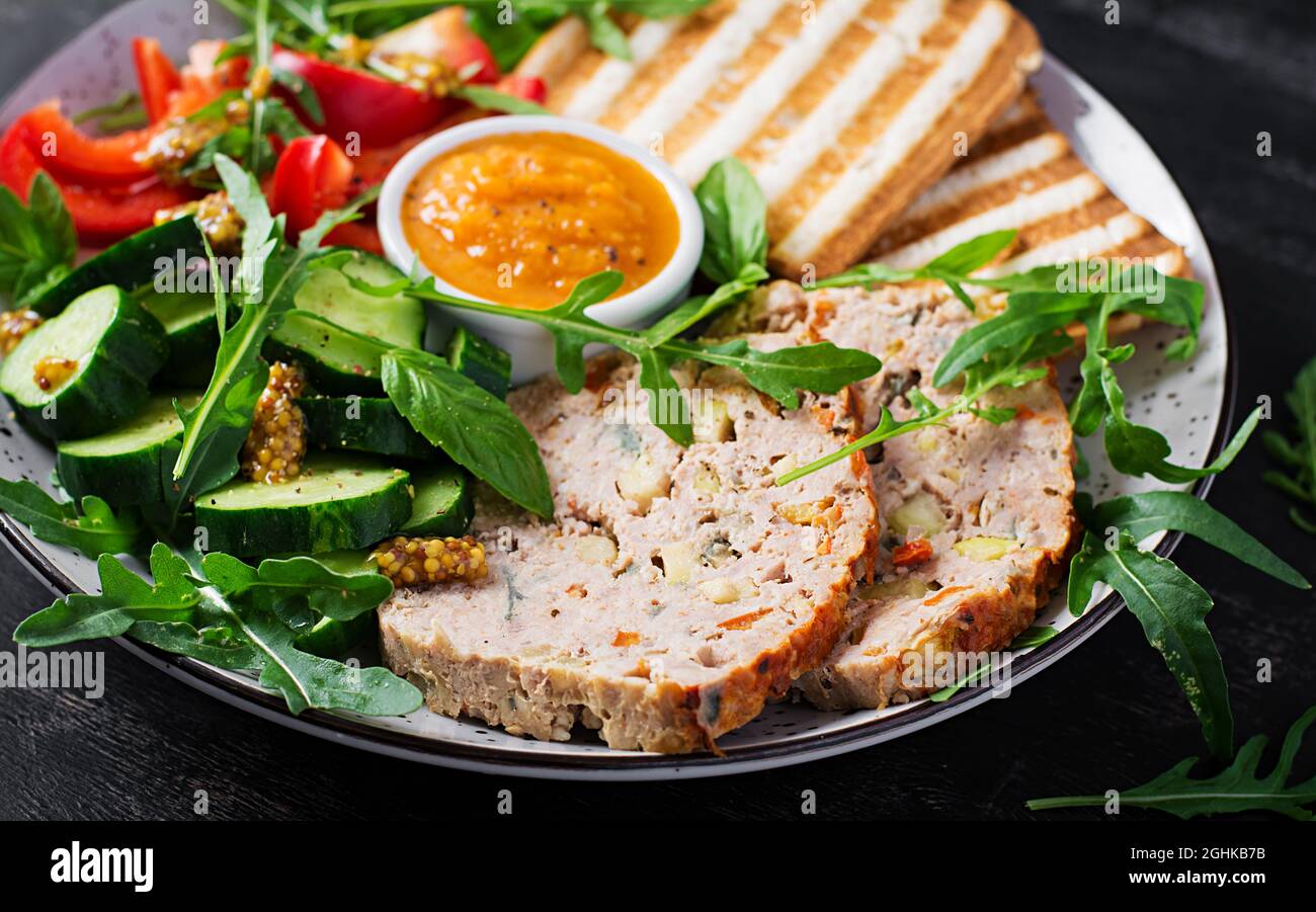 Chicken meatloaf and fresh salad and toasts. Healthy lunch or dinner. Stock Photo