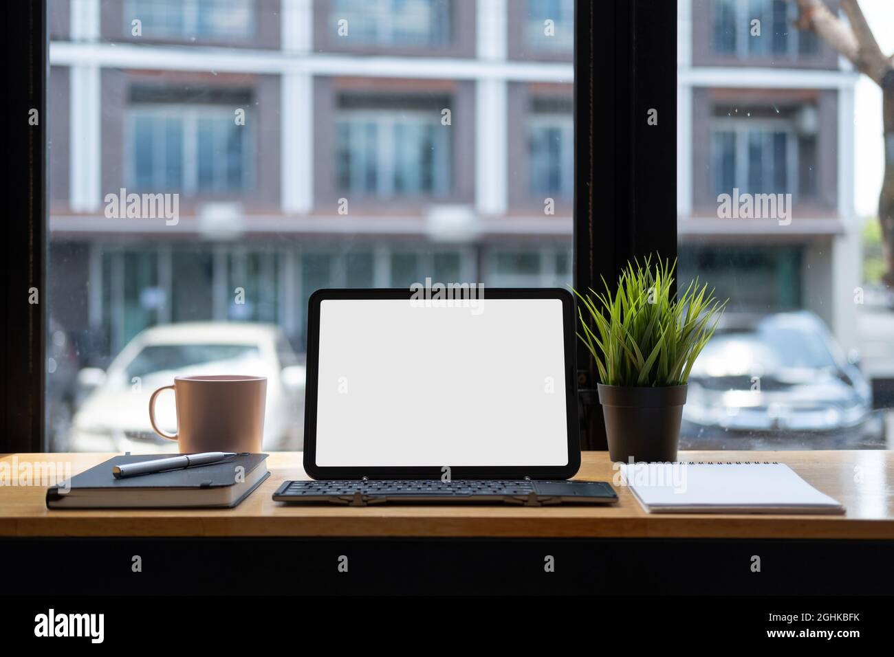 Cropped shot of digital tablet with blank white screen and keyboard, on work desk, copy space Stock Photo