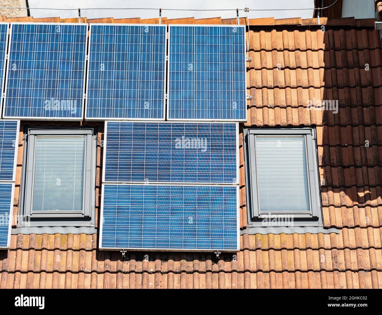 Solar panels for green energy on the tiled red roof of suburban house ...