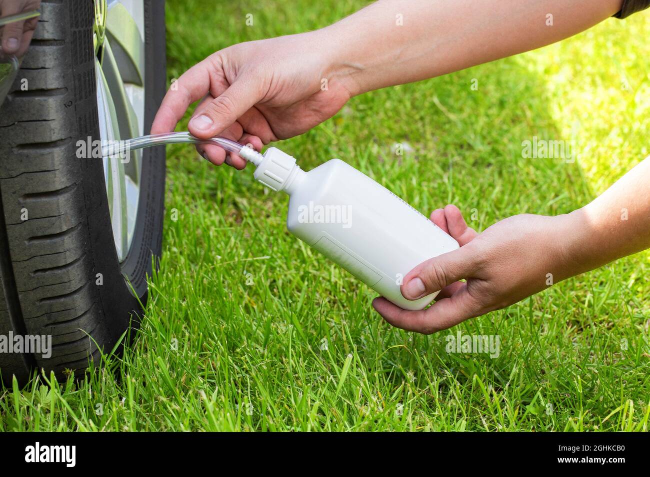 A man pours a car emergency sealant to puncture the wheels. Repairing a