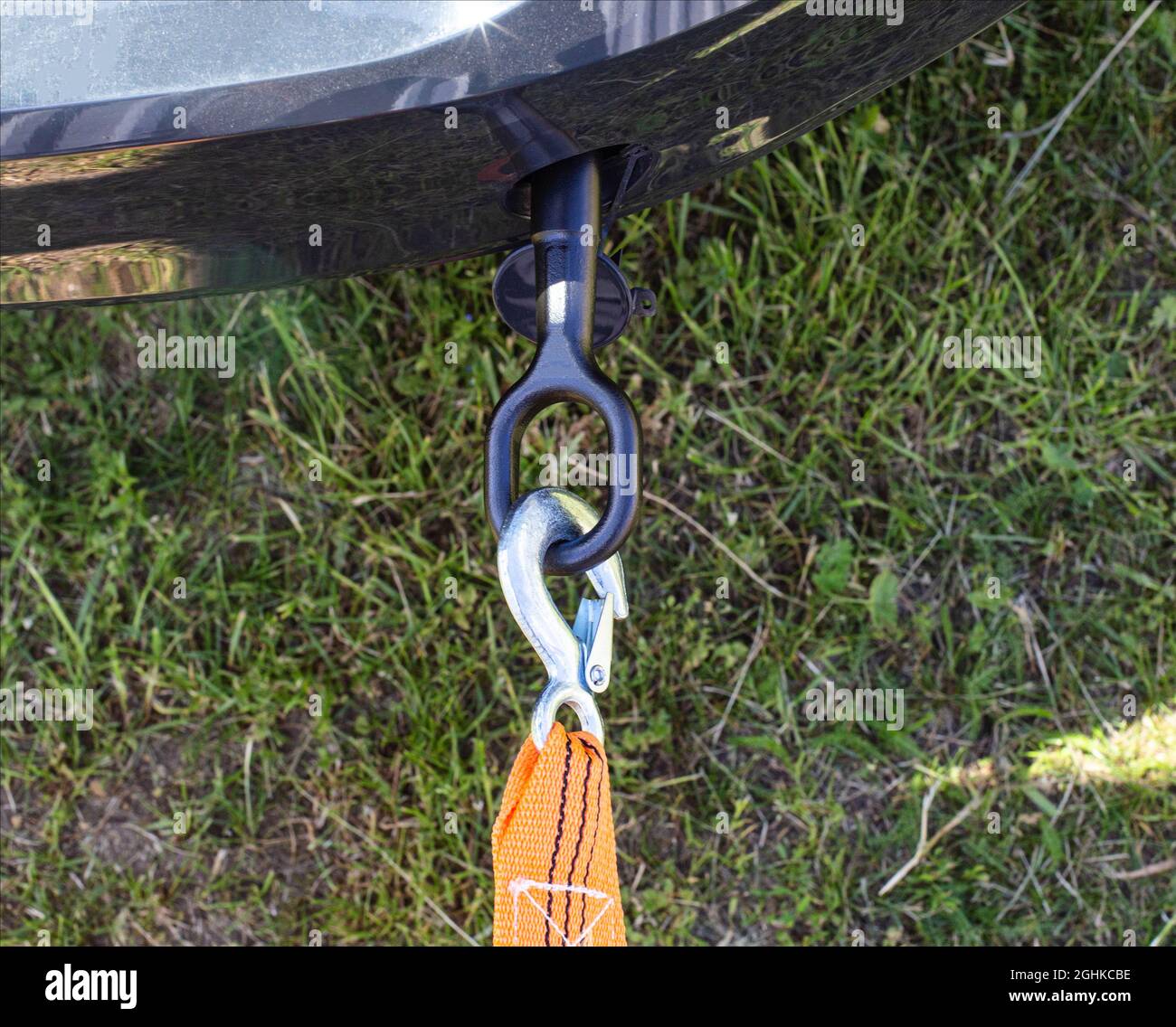 Screws in a tow hook in the car and an orange tow rope for towing