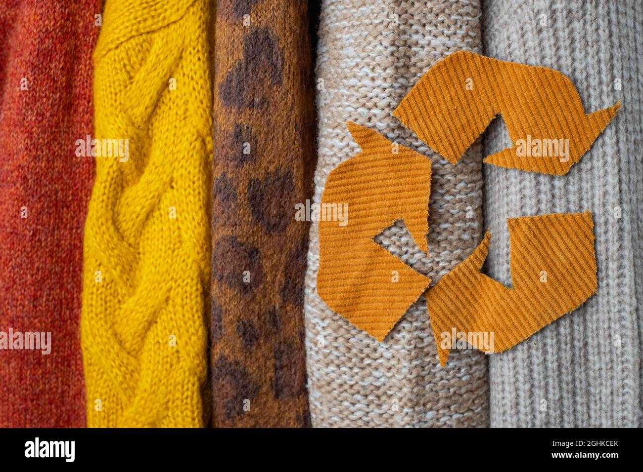 Pieces of corduroy fabric in the form of a sign for processing on the background of autumn knitted sweaters. High quality photo Stock Photo
