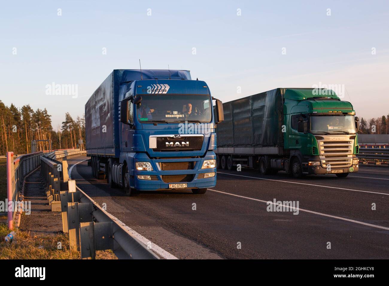 Road Bobruisk-Minsk , BELARUS - July 22, 2019: Two trucks with tilt trailers transport groupage cargo on the highway, logistics and cargo transportati Stock Photo