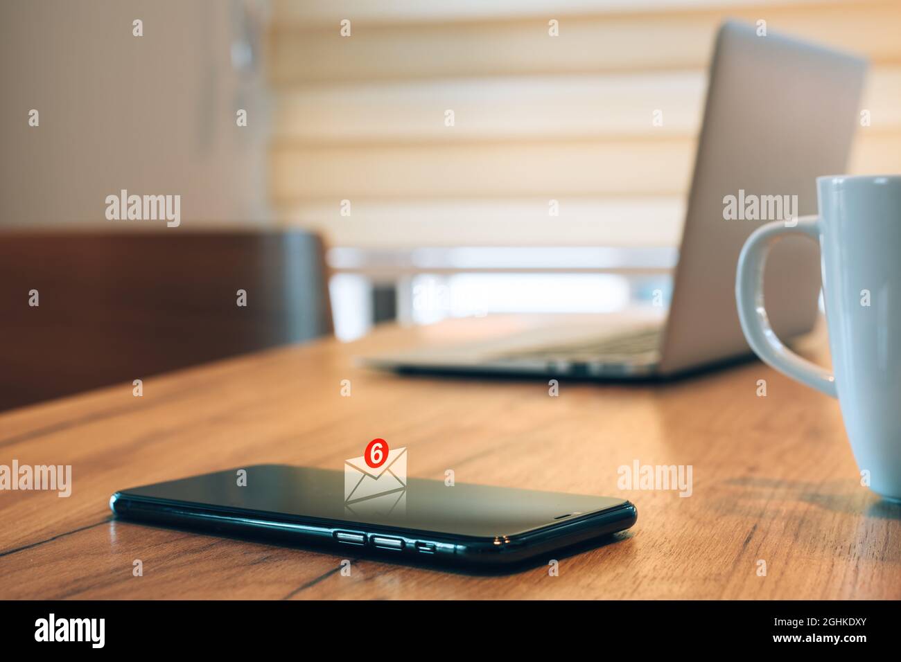E-mail message notification pops up on mobile smart phone in home office, selective focus Stock Photo