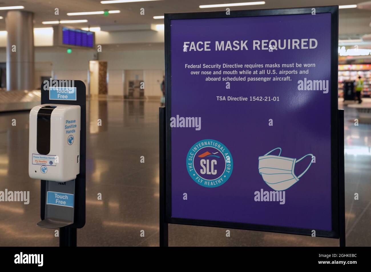A face mask required sign and hand sanitizer dispenser at the Salt Lake City International Airport amid the global coronavirus COVID-19 pandemic, Sund Stock Photo