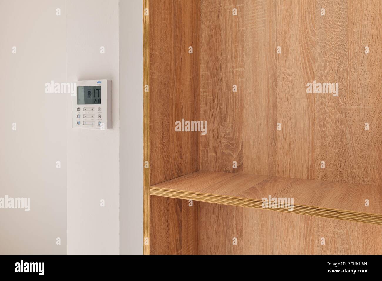 Climate control panel on the wall in a room with wooden builtin