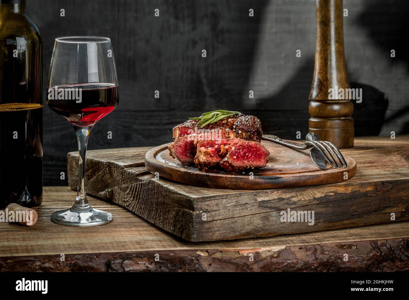 Grilled ribeye beef steak with red wine, herbs and spices on wooden ...