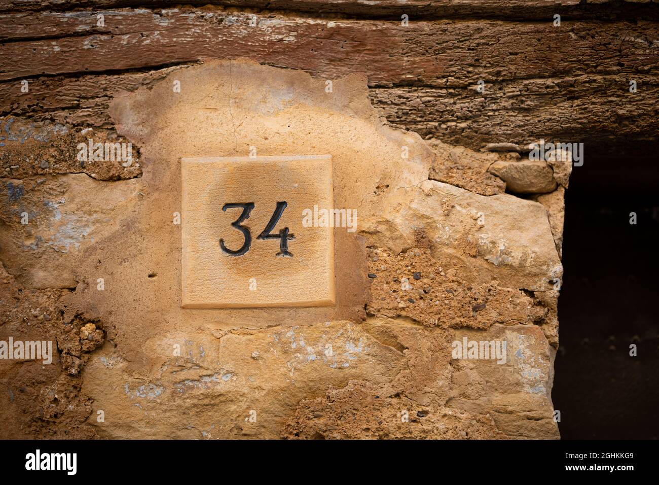 Number thirty four (34) carved on stone at a house door. Vallbona de les Monges, Urgell, Lleida, Catalonia, Spain, Europe. Stock Photo