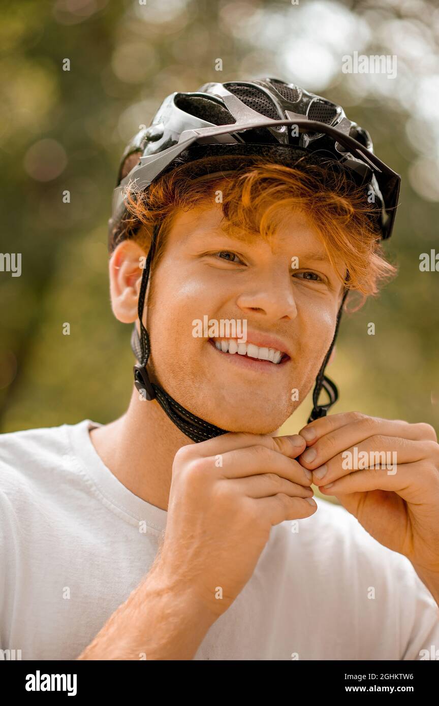 Guy putting on bicycle safety helmet Stock Photo