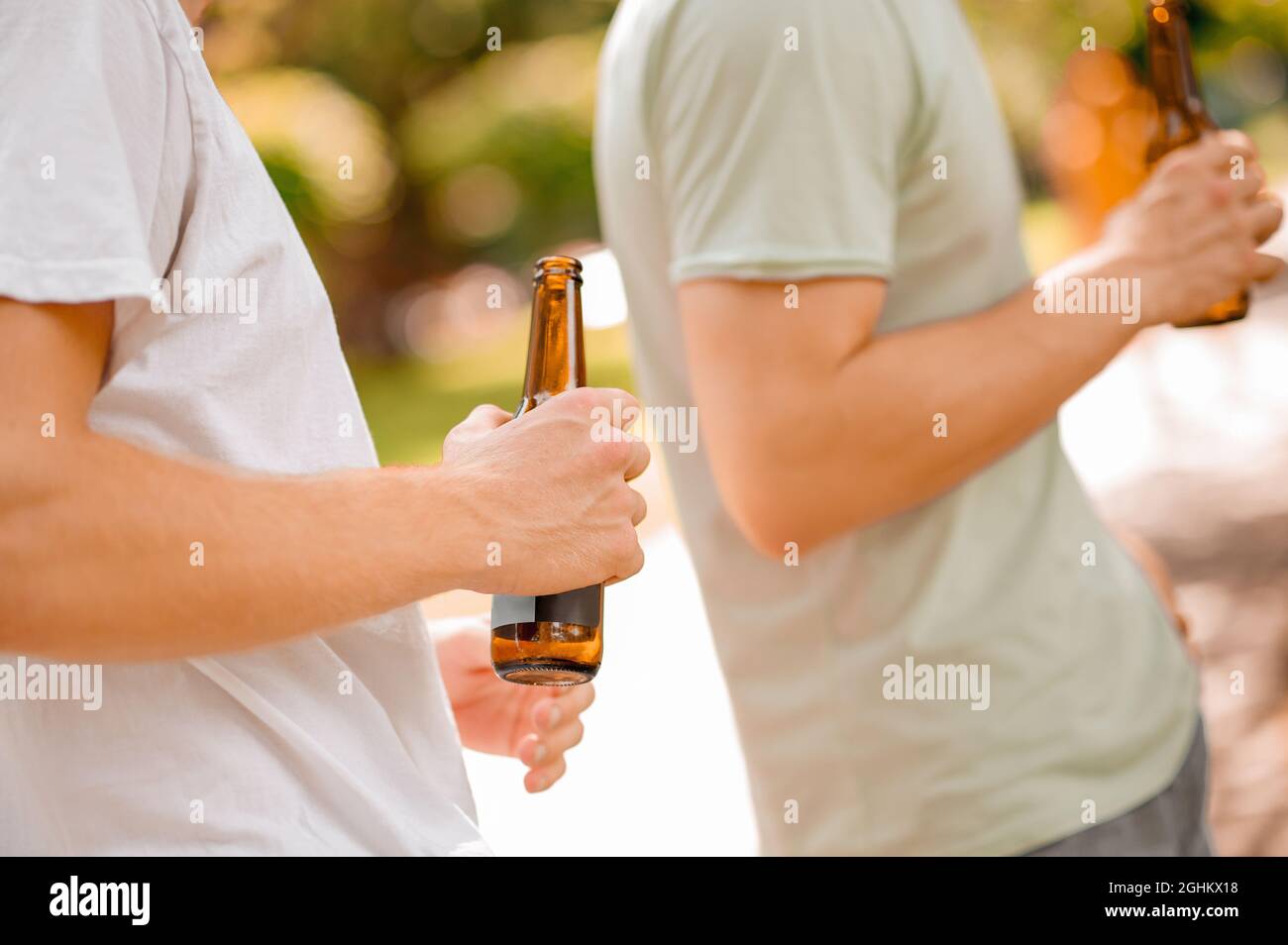 Male hand holding open bottle outdoors Stock Photo