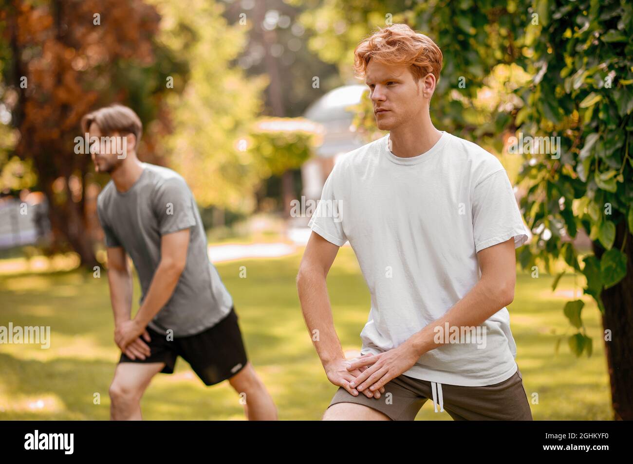 Guys in sportswear doing exercises in nature Stock Photo - Alamy