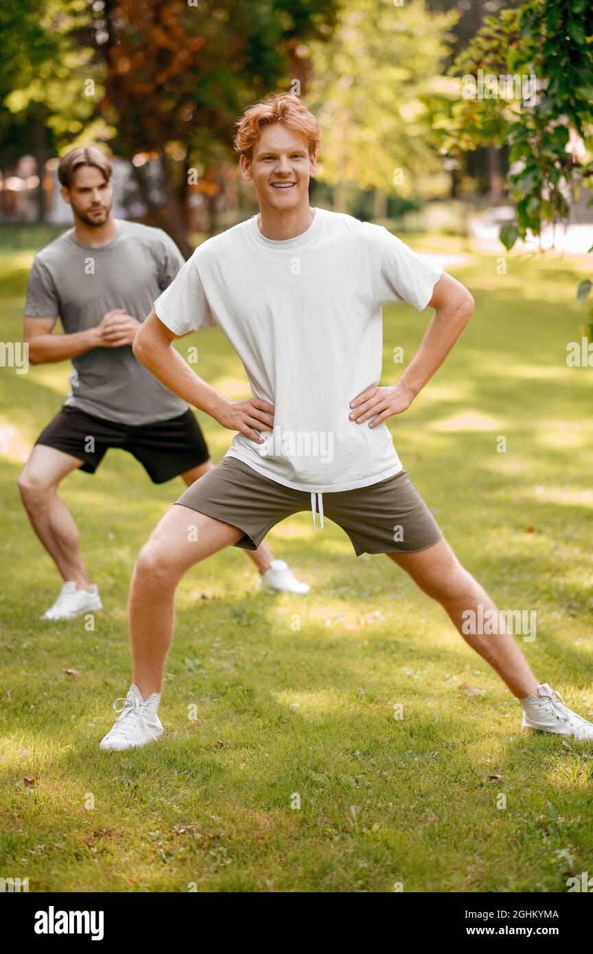 Smiling guys doing sports exercises vigorously Stock Photo Alamy