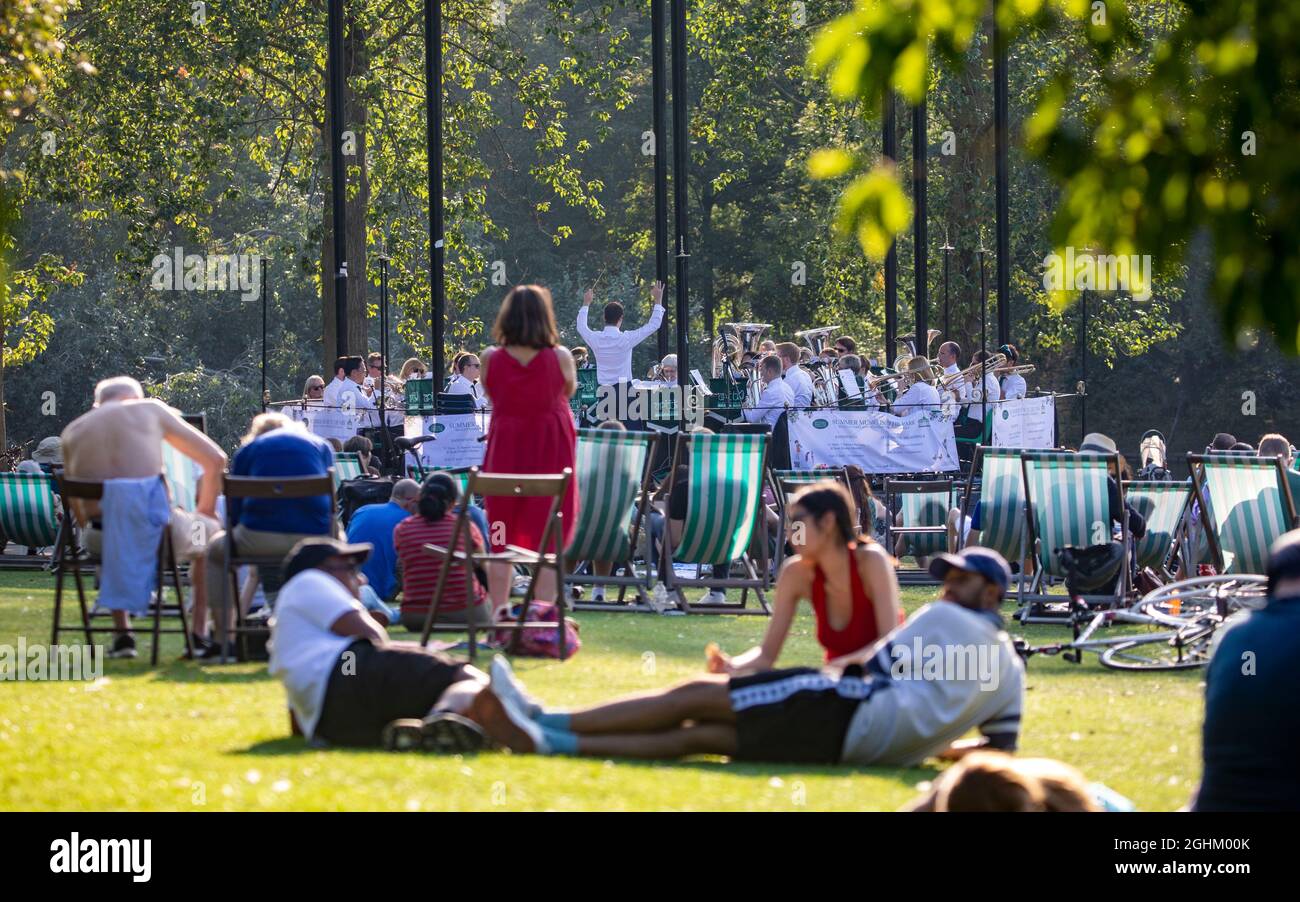 Pic shows: Hot late summer evening on last Sunday of the school holidays. 5.9.21  RegentÕs Park picnickers enjoyed the Kew Wind Orchestra brass band n Stock Photo