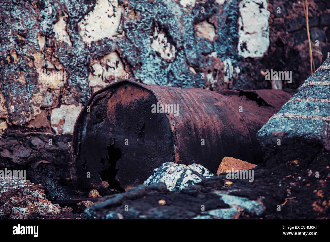 Bidón de metal deteriorado, en balsa de alquitrán y terreno contaminado Stock Photo