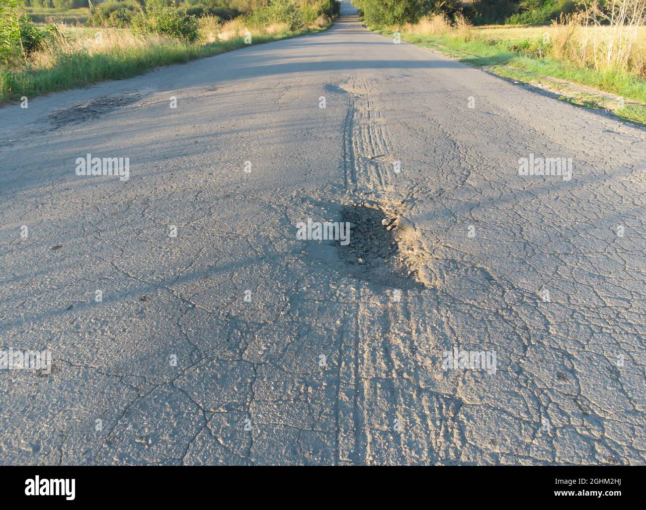 Asphalt road in poor condition with potholes and potholes Stock Photo