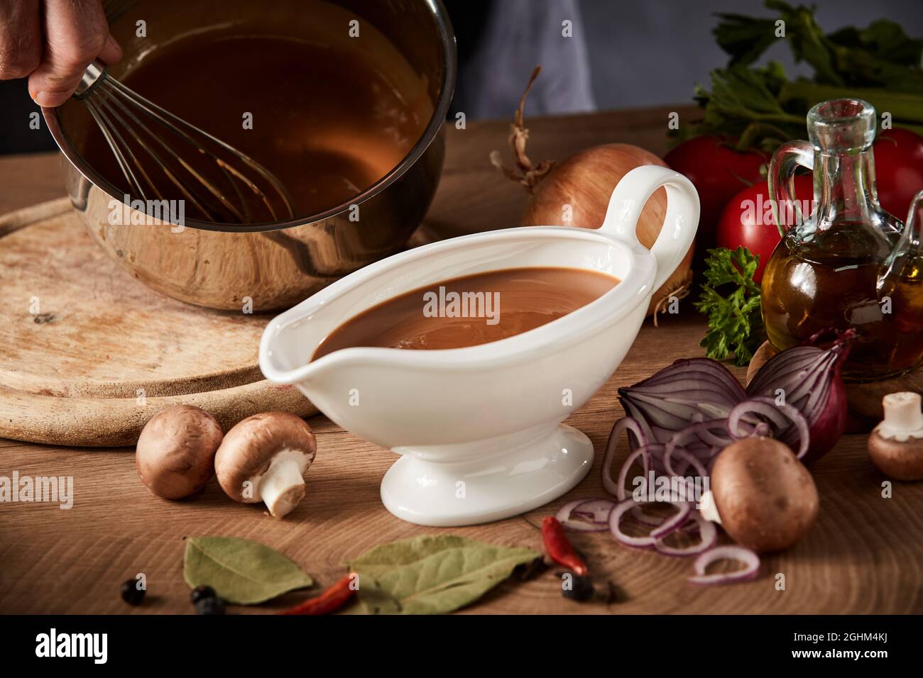 https://c8.alamy.com/comp/2GHM4KJ/chef-preparing-a-serving-of-delicious-spicy-rich-gravy-whisking-it-in-a-pot-with-a-close-up-view-on-a-full-sauce-boat-or-pitcher-in-the-foreground-2GHM4KJ.jpg