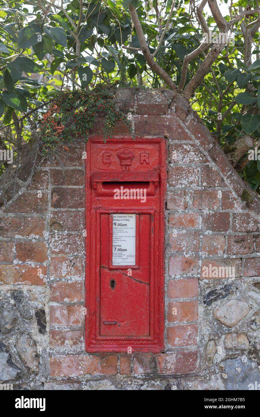 cracked post box built in to a brick wall, Worthing, West Sussex, UK Stock Photo