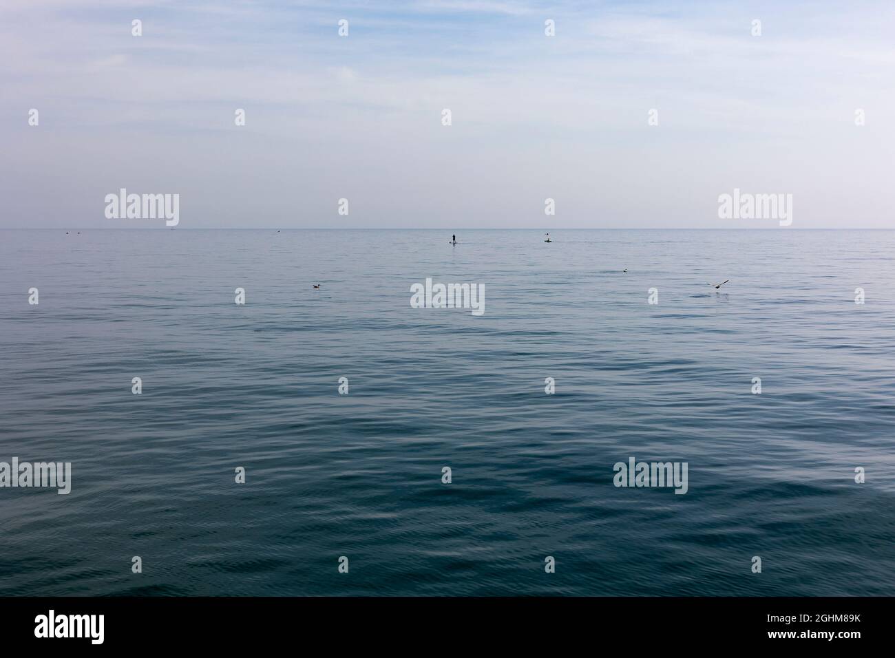 unrecognisable people paddle boarding off the coast in Worthing, West Sussex, UK, September 2021 Stock Photo