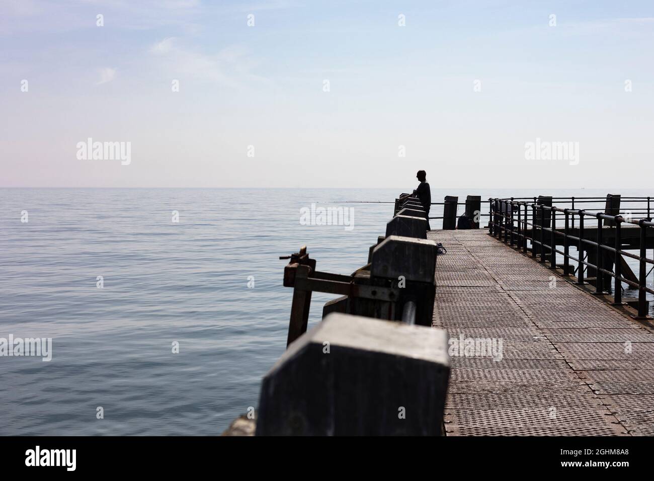 man fishing off the pier in Worthing, West Sussex, UK, September 2021 Stock Photo