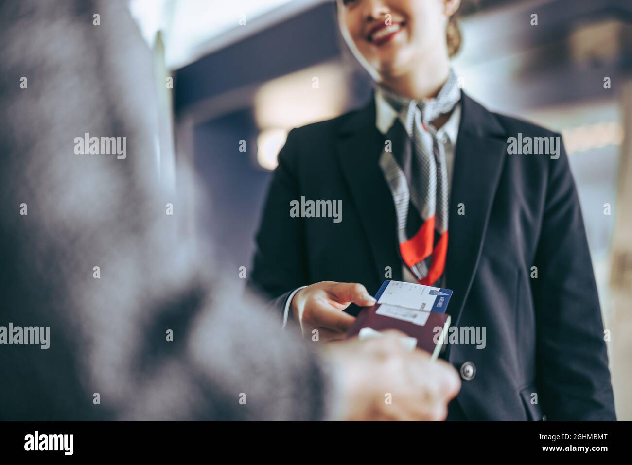 Cropped shot of airlines staff checking passenger at check-in counter. Flight attendant checking tourist boarding pass at airport. Stock Photo
