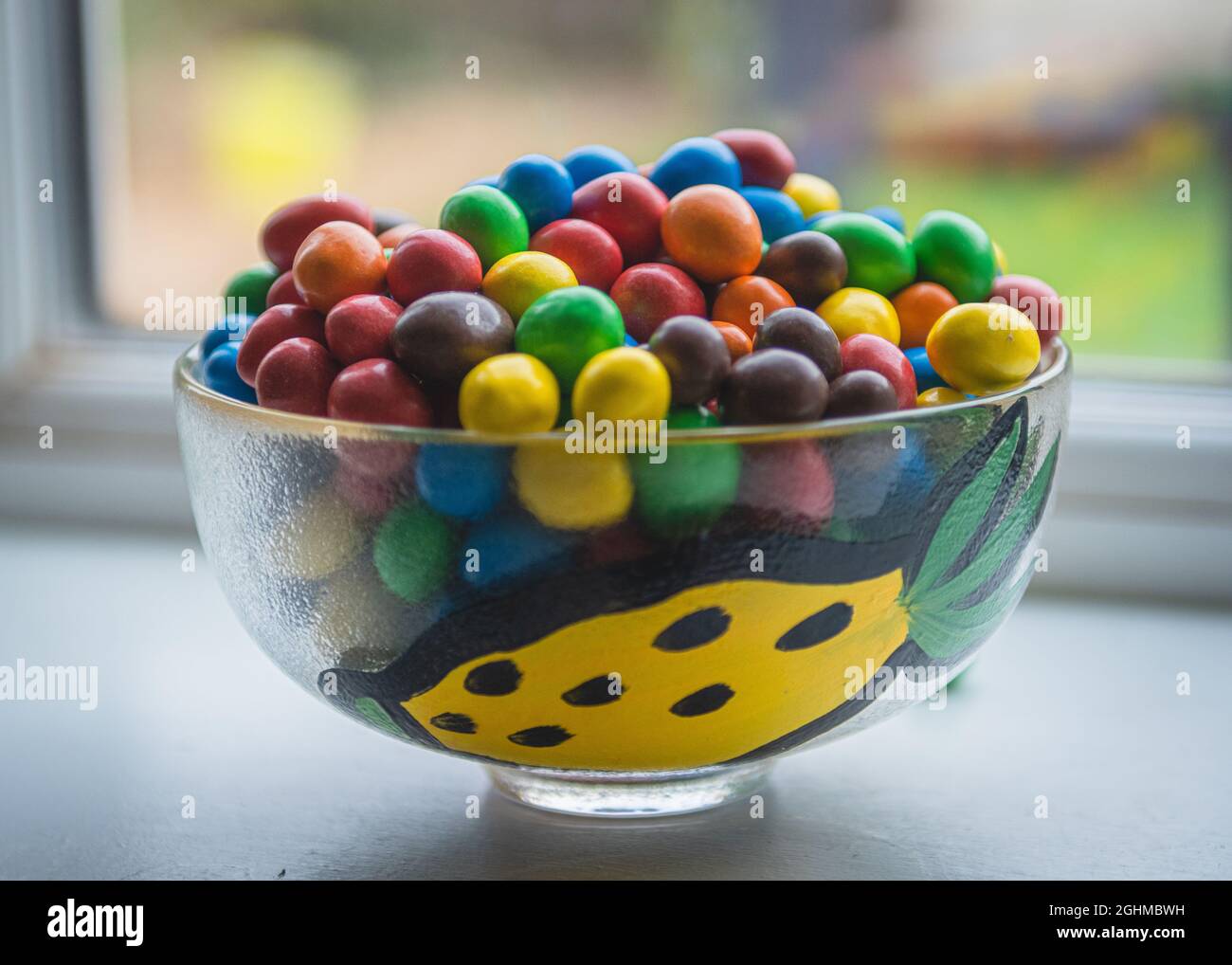 Glass bowl of bright coloured candy Stock Photo Alamy