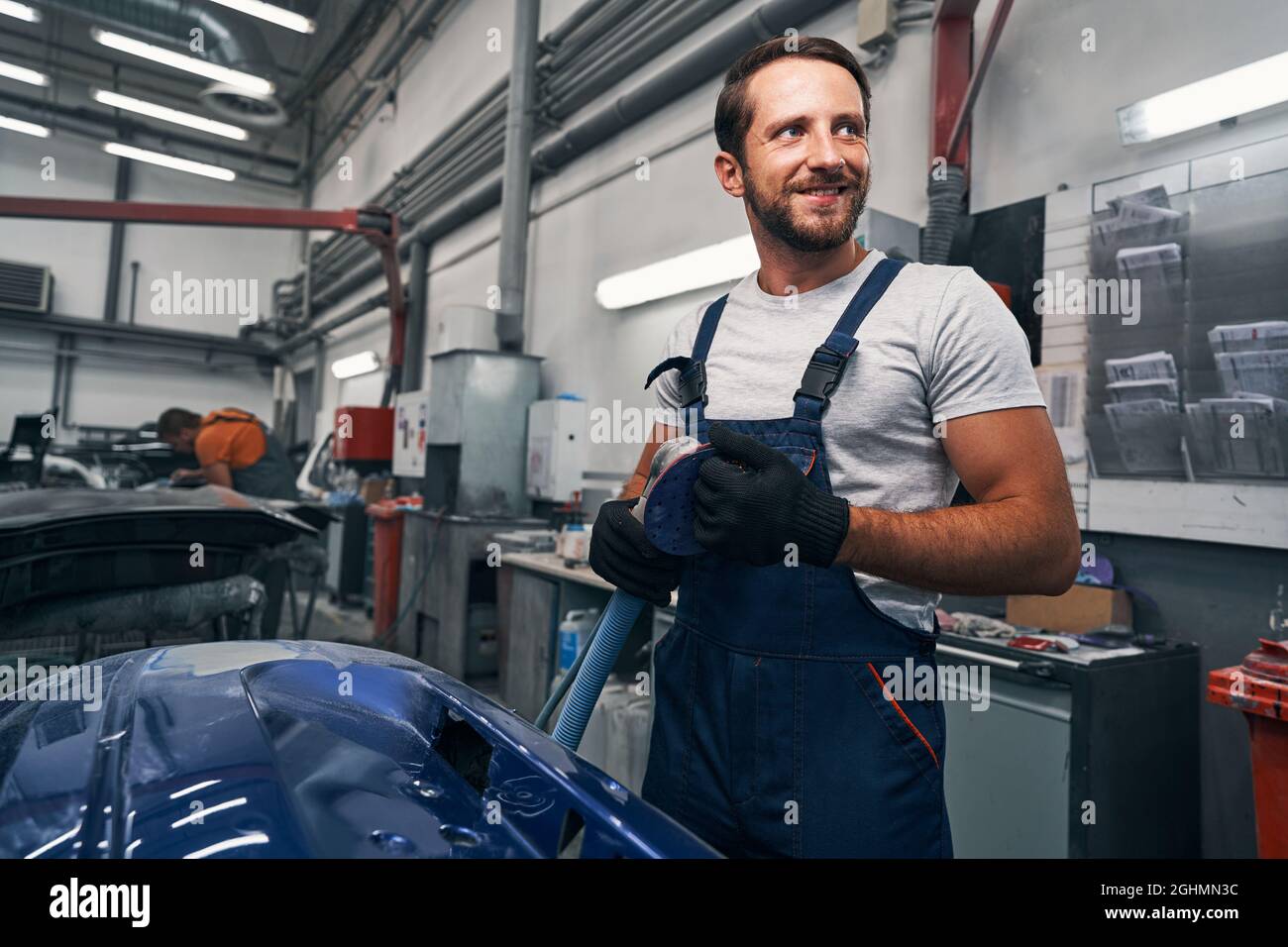 Male car workshop worker taking care of sander after work Stock Photo