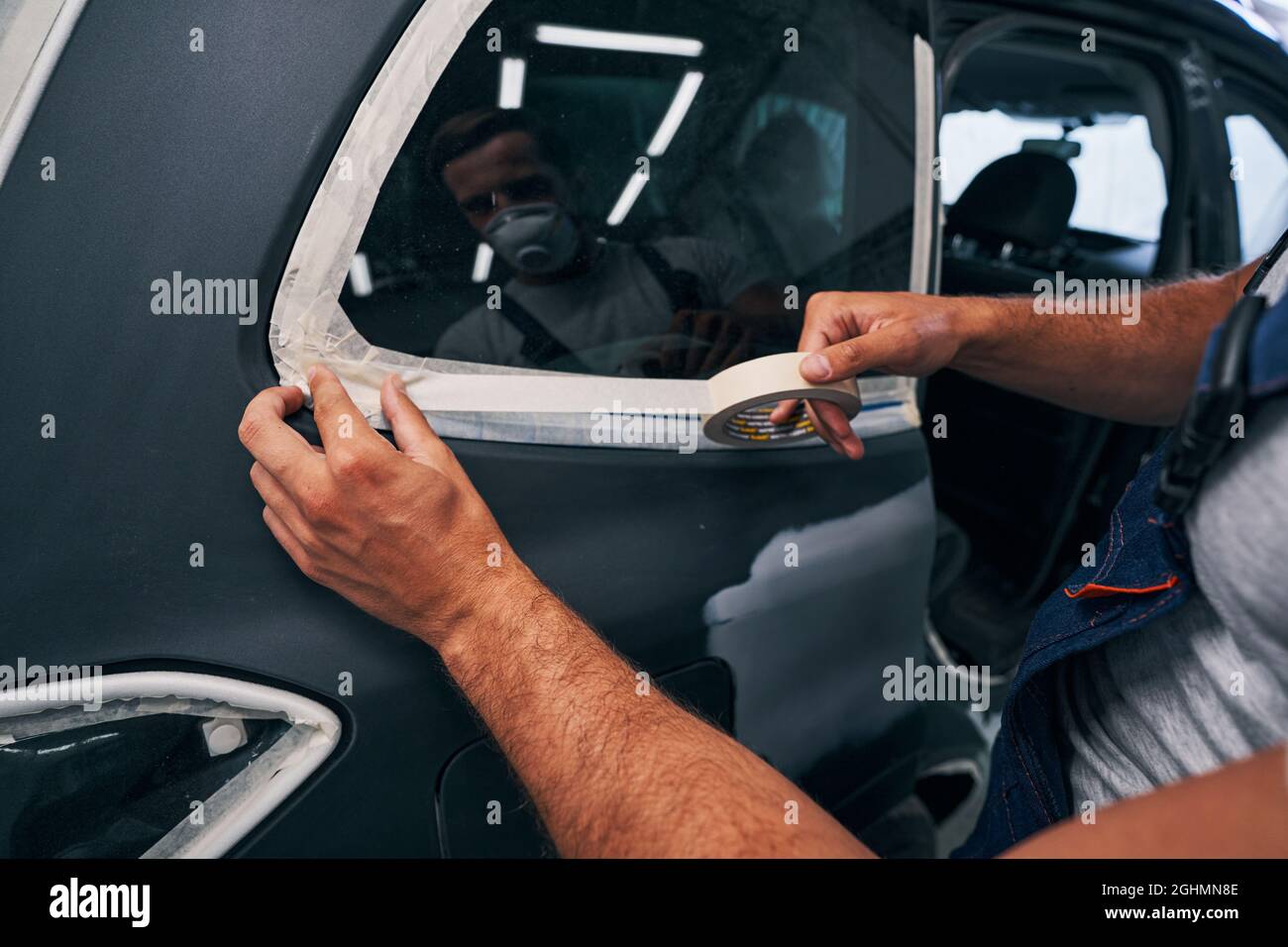 Person isolating car windows with duct tape Stock Photo