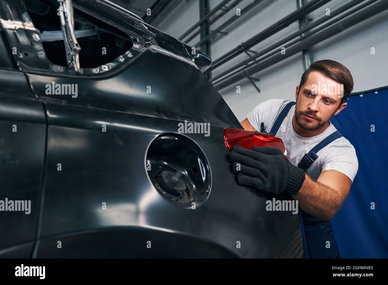 Repairman straightening rear light in its place Stock Photo