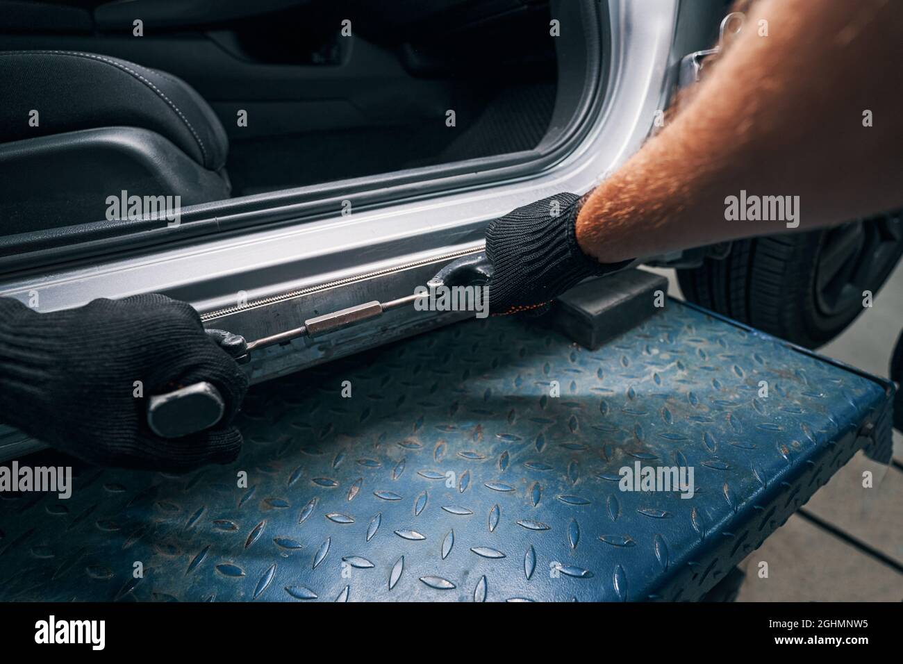 Straightening of car frame surface with peening instrument Stock Photo