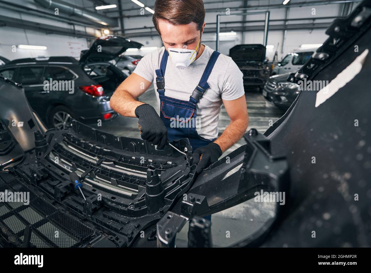 Car repairman reaching inside a car with wrench Stock Photo