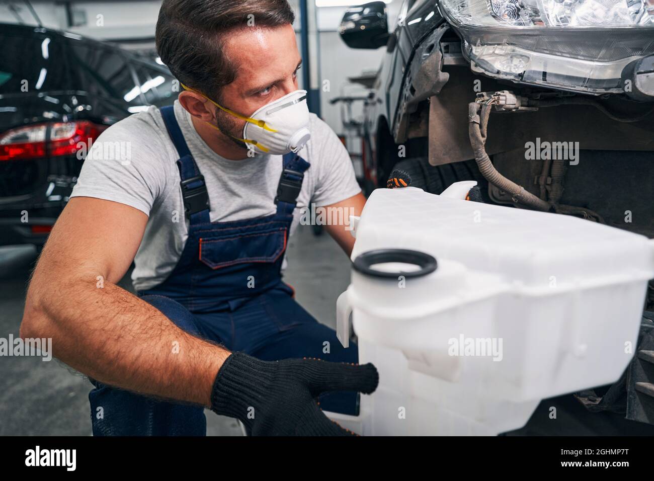 Washer bottle in hand of car technician Stock Photo