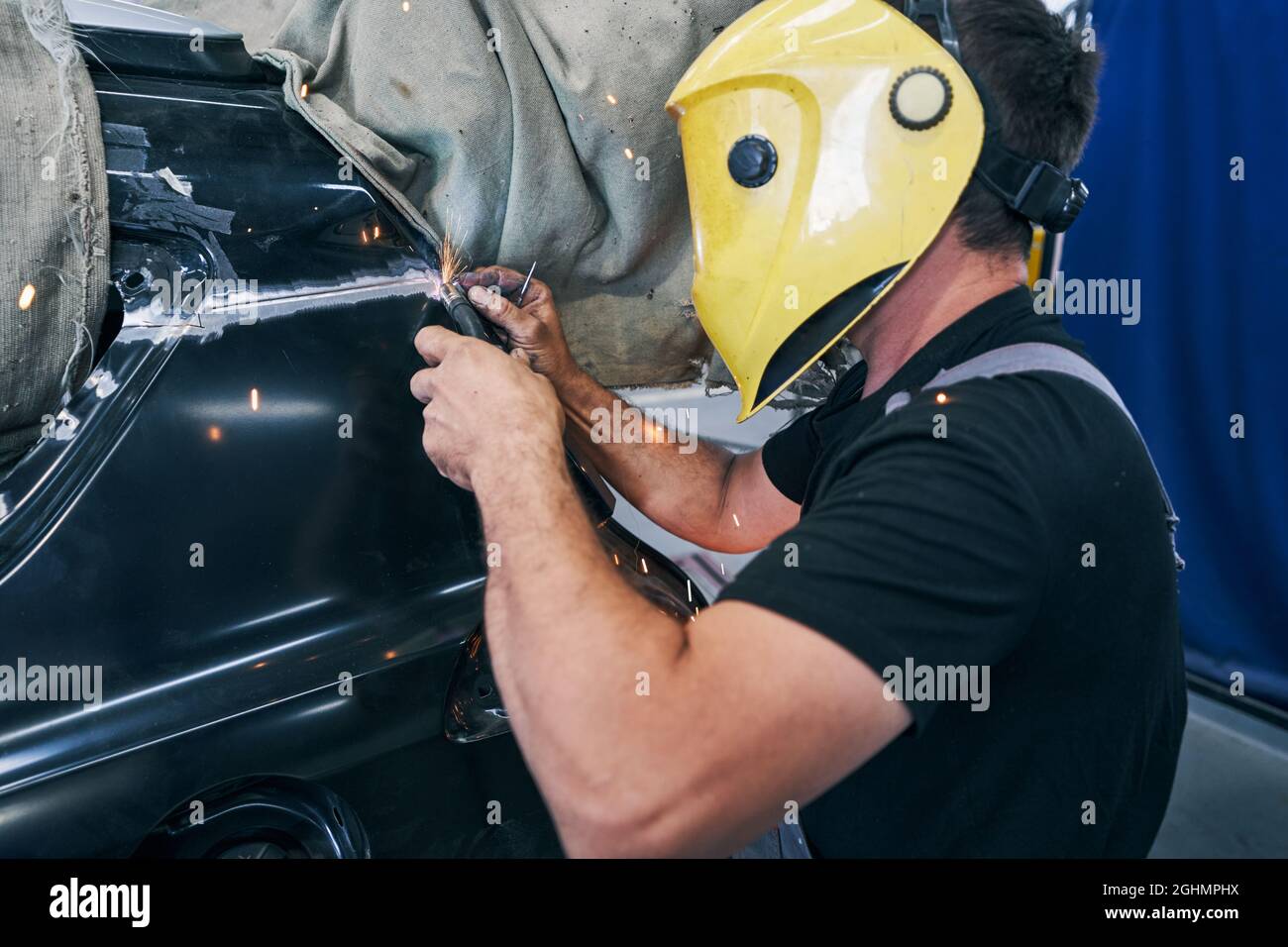 Car mechanic using welding machine on automobile Stock Photo