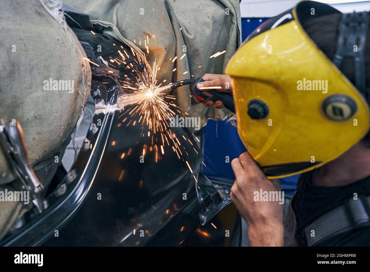 Welder using machine for welding a joint on auto surface Stock Photo
