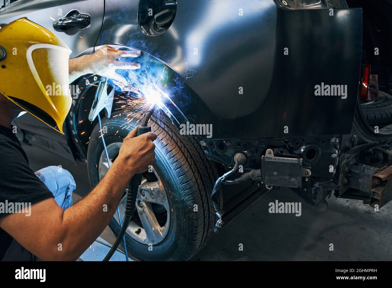 Man working with welding machine on wheel arch cover Stock Photo