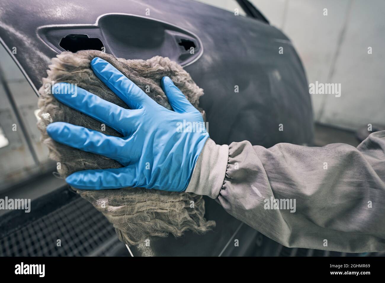 Person in rubber glove wiping car with rag Stock Photo