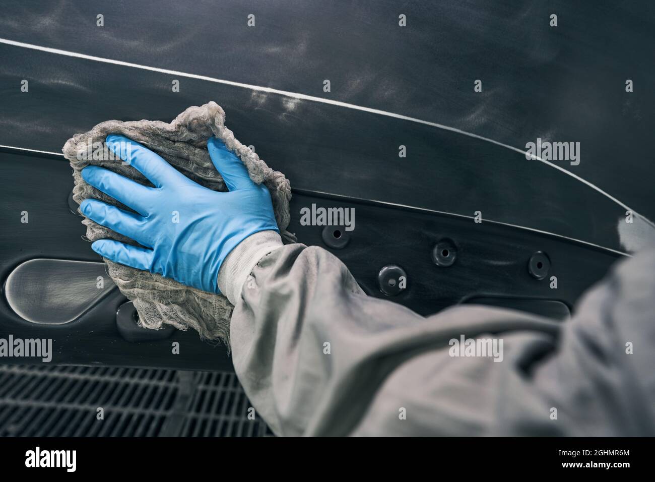 Mechanic unoiling automobile surface with wiping cloth Stock Photo